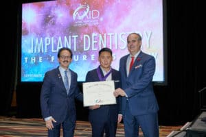 American Academy of Implant Dentistry giving the Fellow Certification to Fred J. Kim, DDS of Pacific Smiles